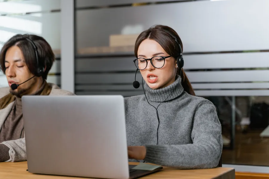 Customer service professional using a headset and laptop